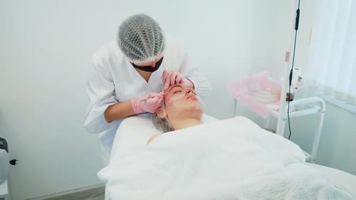 Woman Addressing Pigmentation Issues on Girl Face Female Professional Performing Dermatological