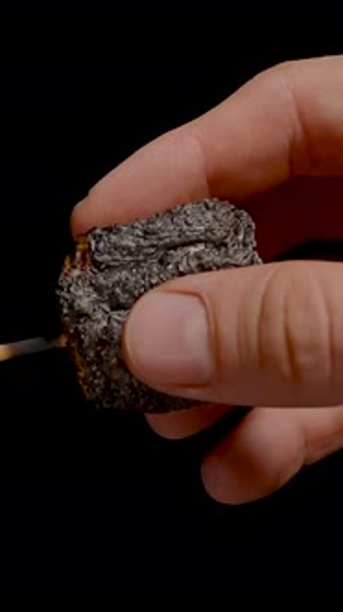 Vertical video. Hand Pulling Burnt Marshmallow Off Stick with Gooey Melted Center Stretching on
