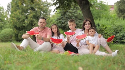 Happy Family Eating Watermelon at Park Picnic