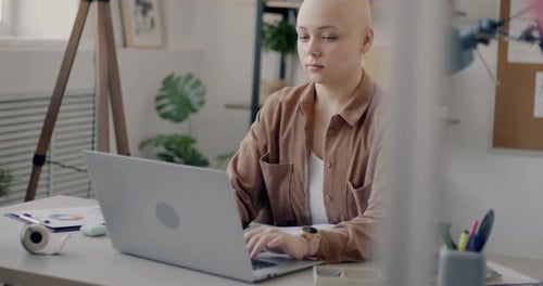 Young Office Worker Typing Using Laptop Concentrated on Job in Comfortable Workplace