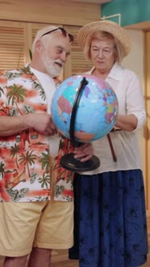 Senior Couple Planning Vacation with Globe at Home
