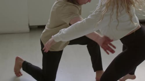 Man and Woman Dance Acrobatically in Bright Room