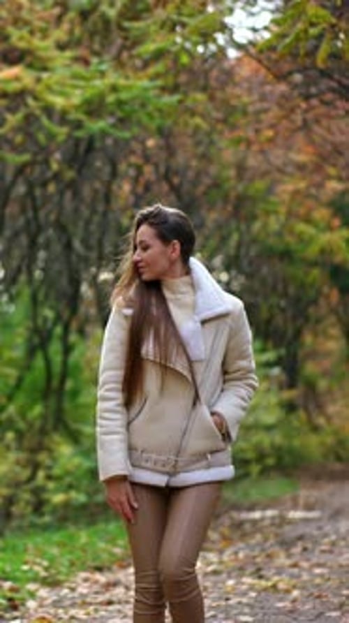 Stylish Woman Walking Through Autumn Park