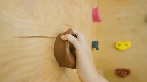 Close-up of a young girl climbing an indoor rock climbing wall.