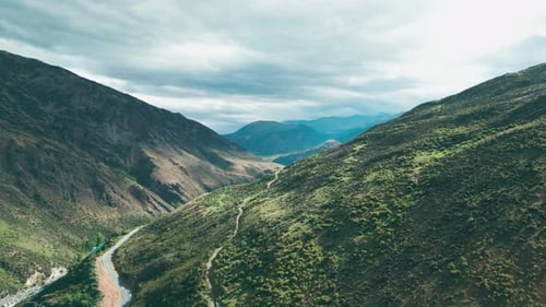 Drone survolant une rivière entre deux chaînes de montagnes