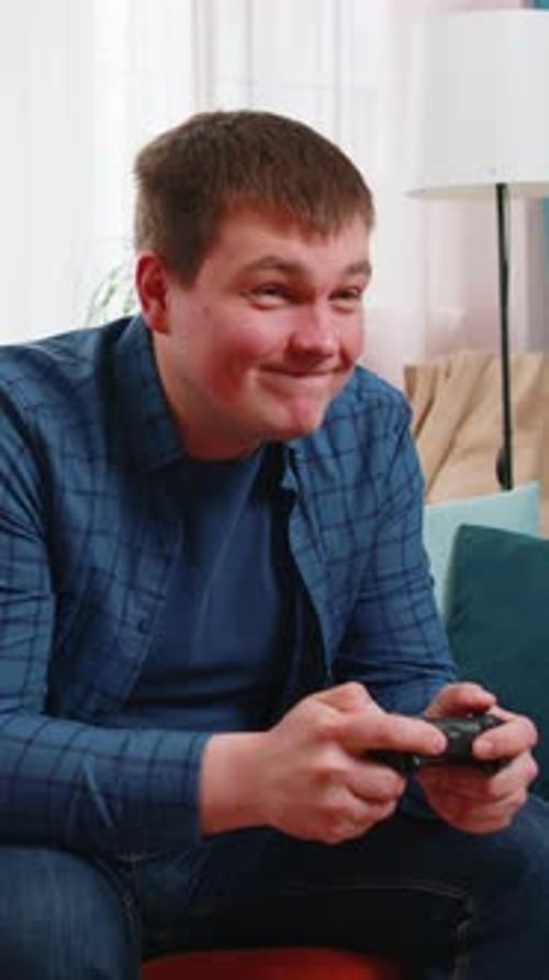 Man Sitting Playing Video Game, Cheering and Smiling