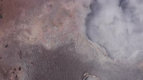Aerial at active volcanic mud pool bubbling wildly with steam, Gunnuhver geyser