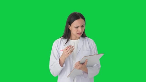 Angry Indian female scientist taking notes Green screen