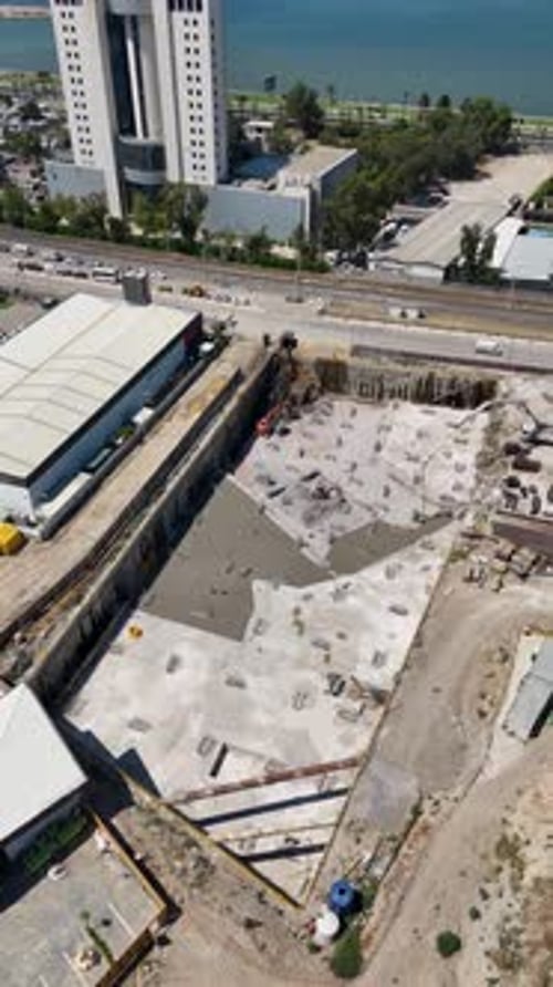 Vertical Drone Footage of Construction Site with Heavy Machinery – 4K