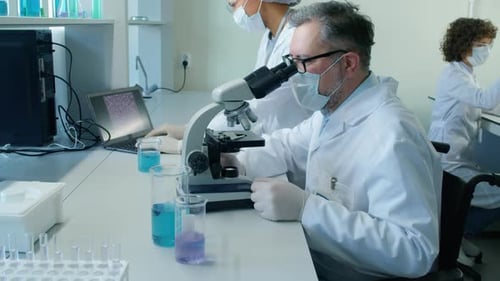 Scientists Working With Microscopes in a Bright Lab