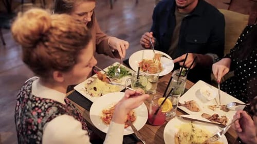 Friends Enjoying Meal and Drinks Together at Restaurant