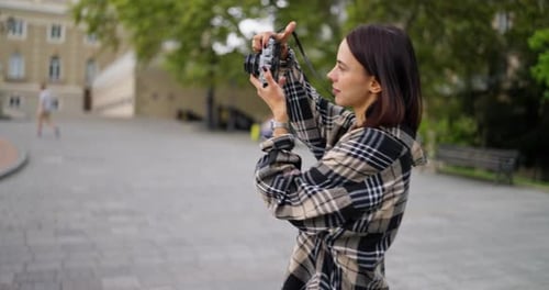 Young Woman Taking Pictures in Urban Park