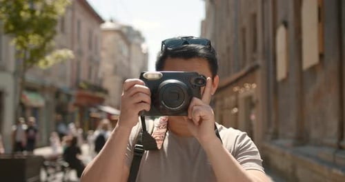 Male Photographer Taking Photos of an Old Town with Digital Camera