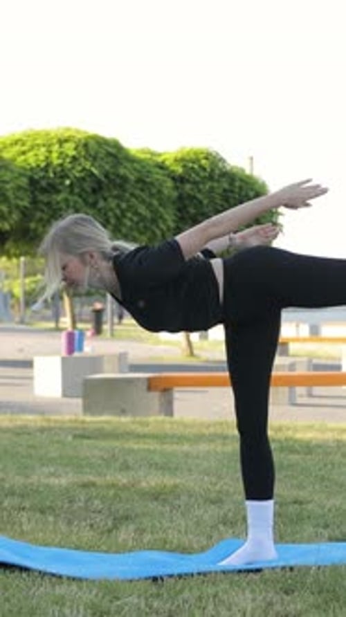 Woman Balances in Yoga Pose Outdoors