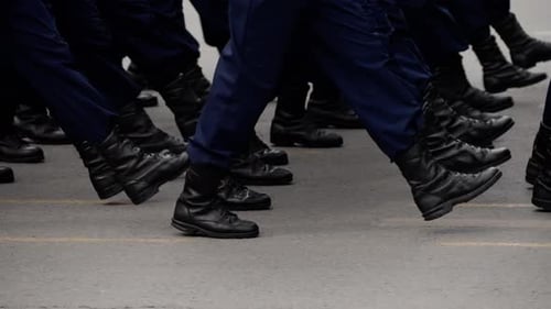 Marching uniformed figures with boots in the city