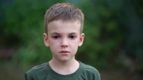 Boy Looking Sad in front of Forest Background