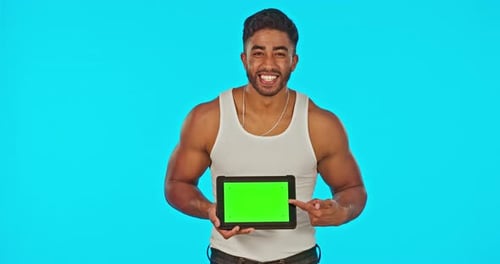 Visage, écran vert et homme avec tablette pointant dans un studio isolé sur fond bleu