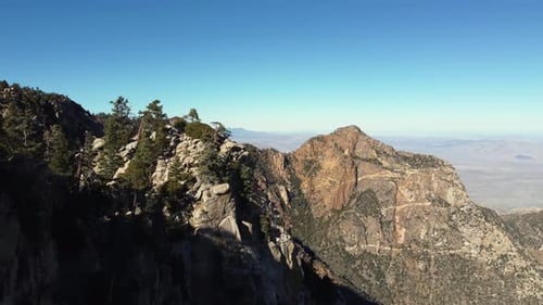 Aerial flies past rugged rock cliffs in arid mountains of Baja, Mexico