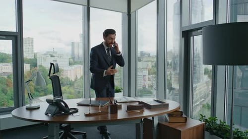 Angry Businessman Finish Phone Call Standing In Modern Office. Middle-Aged Nervous Entrepreneur S...