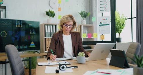 Woman Working at Desk With Laptop in Modern Office