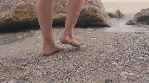 Bare Feet Walking on Sandy Beach at Sunset