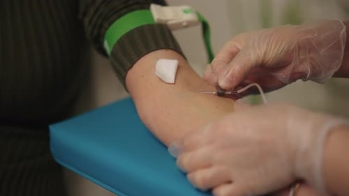 Closeup of Medical Professional Performing Blood Draw From Patient Arm Collecting Sample for