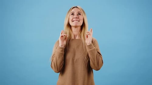 Woman Makes Wish Crossing Fingers with Pleading Expression
