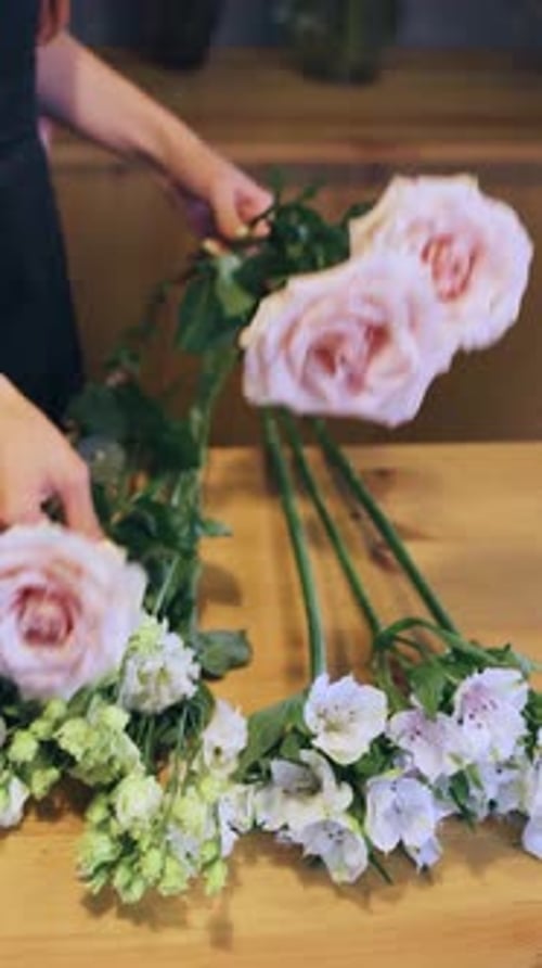Floral Designer Creates Pretty Floral Arrangement on Table