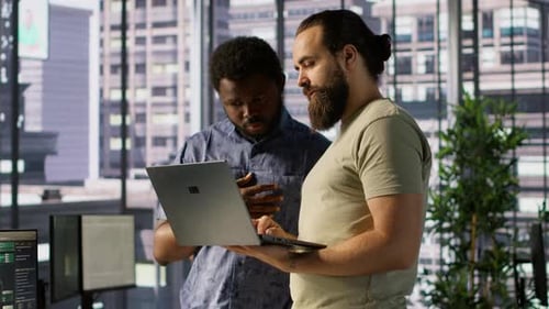 Entwickler und Kollege überprüfen Code auf dem Notebook beim Brainstorming