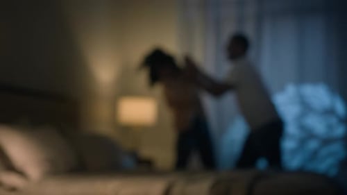 Blurred Argument Between Couple in Bedroom at Night