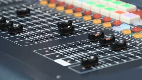 Hand adjusting audio console knob in professional recording studio