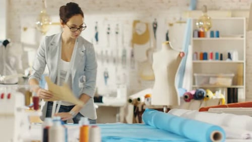 Fashion Designer Laying Out Pattern On Fabric