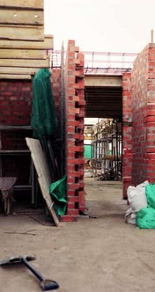 Pared de ladrillos al aire libre, de construcción o vacía en el sitio para el progreso del desarrollo, la construcción o el equipo