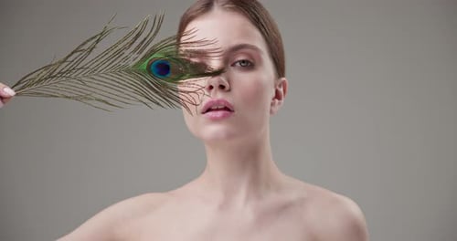 Beautiful Woman Posing with Peacock Feather