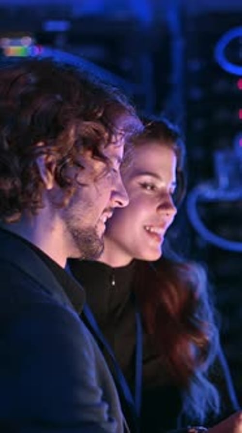 Two Young Adults Discuss Tech in Server Room