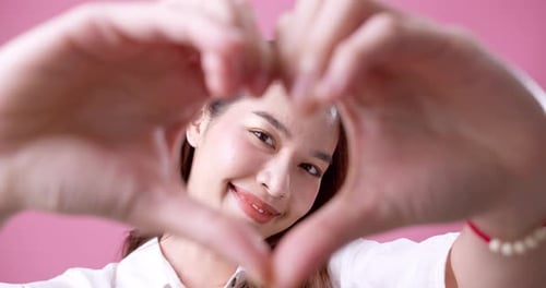Smiling Woman Makes Heart Shape With Hands