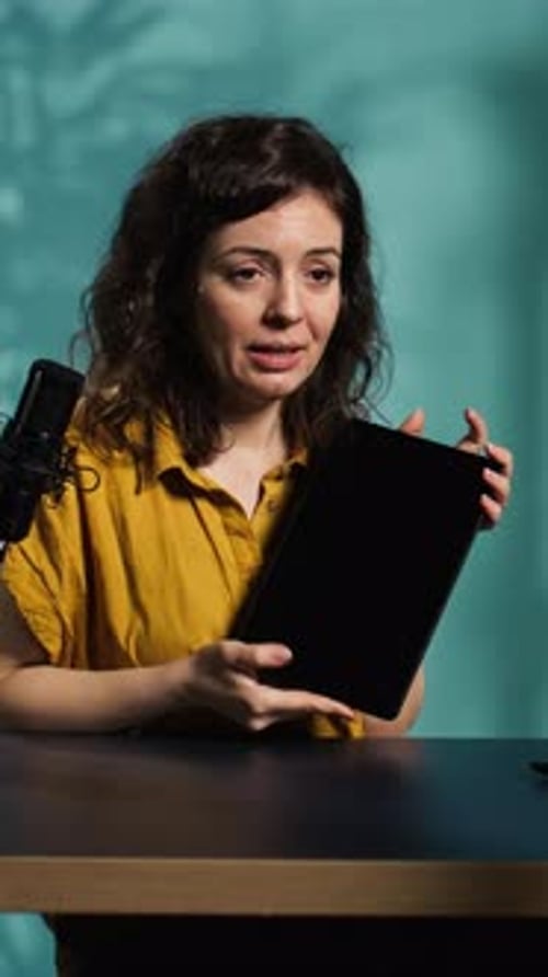 Young Woman Talking about Tablet at Desk