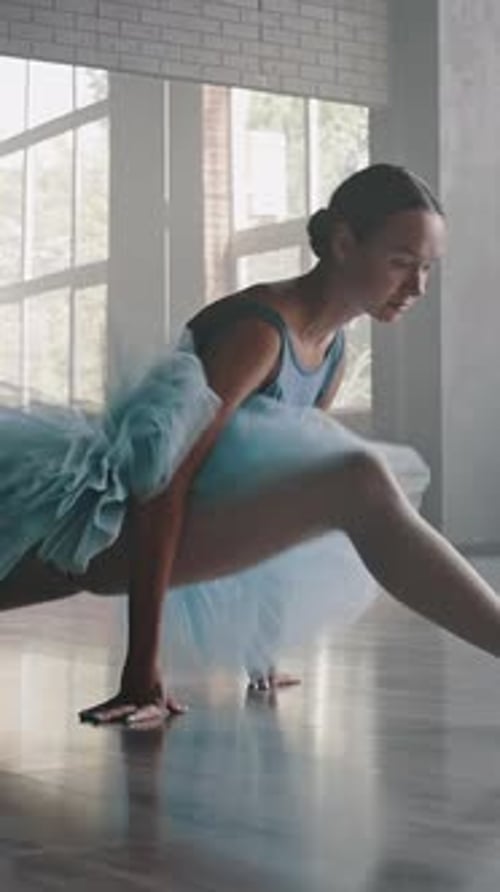 Elegant Ballerina Stretching into Split in Dance Studio