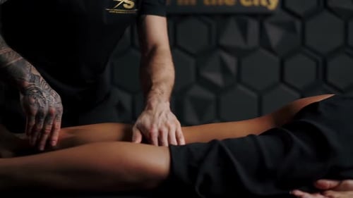 Person Receiving Leg Massage in Dimly Lit Room