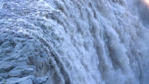 Hydroelectric Power. Slow Motion Waterfall Dettifoss Iceland. Blue Water and Rocks in Close Up