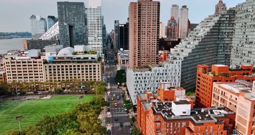 Footage above the busy wide road going along futuristic modern architecture. New York view from top.