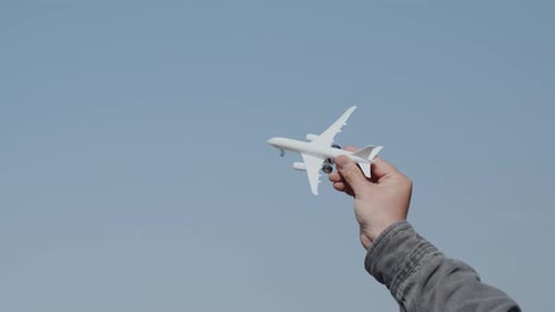 Toy Plane and Real Airplane in Blue Sky