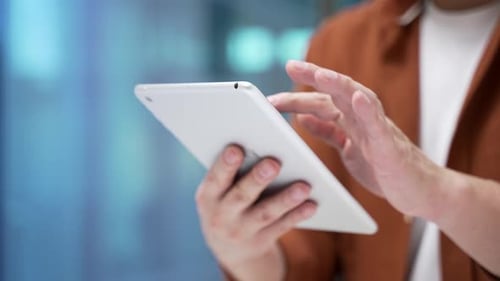 Close up of asian male hands holding digital tablet at workplace in business office. Businessman
