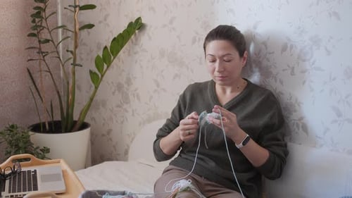 Woman Knitting with Yarn at Home