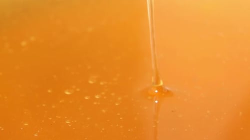 A Thin Stream of Clear Fresh Honey Slowly Pours