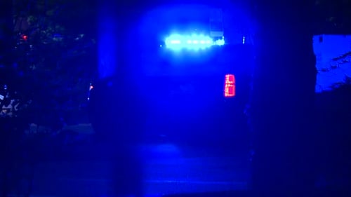 GEPARKTES POLIZEIKREUZER MIT EINGESCHALTETEM LICHT IN DER NACHT