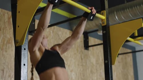 Athlete performs pull-ups in training session at gym to improve upper body strength and endurance