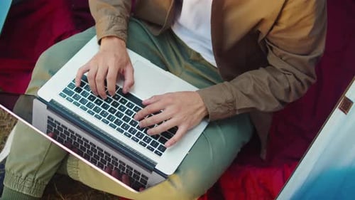 Homem turista usando computador portátil no acampamento, vista superior