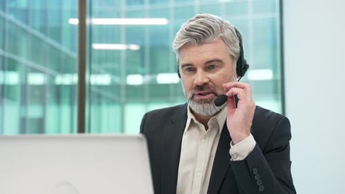 Professional Man Video Conferencing with Headset in Office