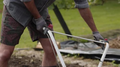Gardener At Work Holding Rotavator For Garden Cultivation. closeup shot